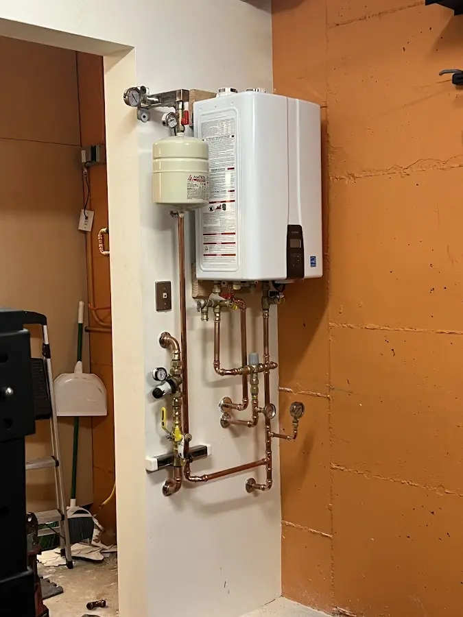 Plumbing technician inspecting water heater connections in Doylestown